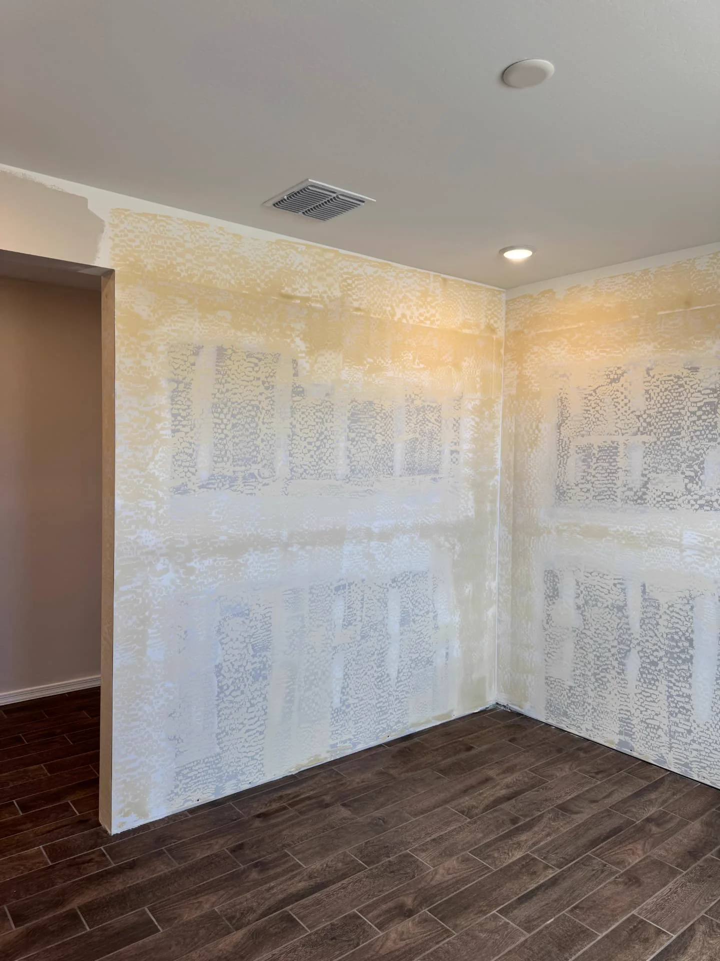 Corner of a room with drywall mudded and taped before texture application