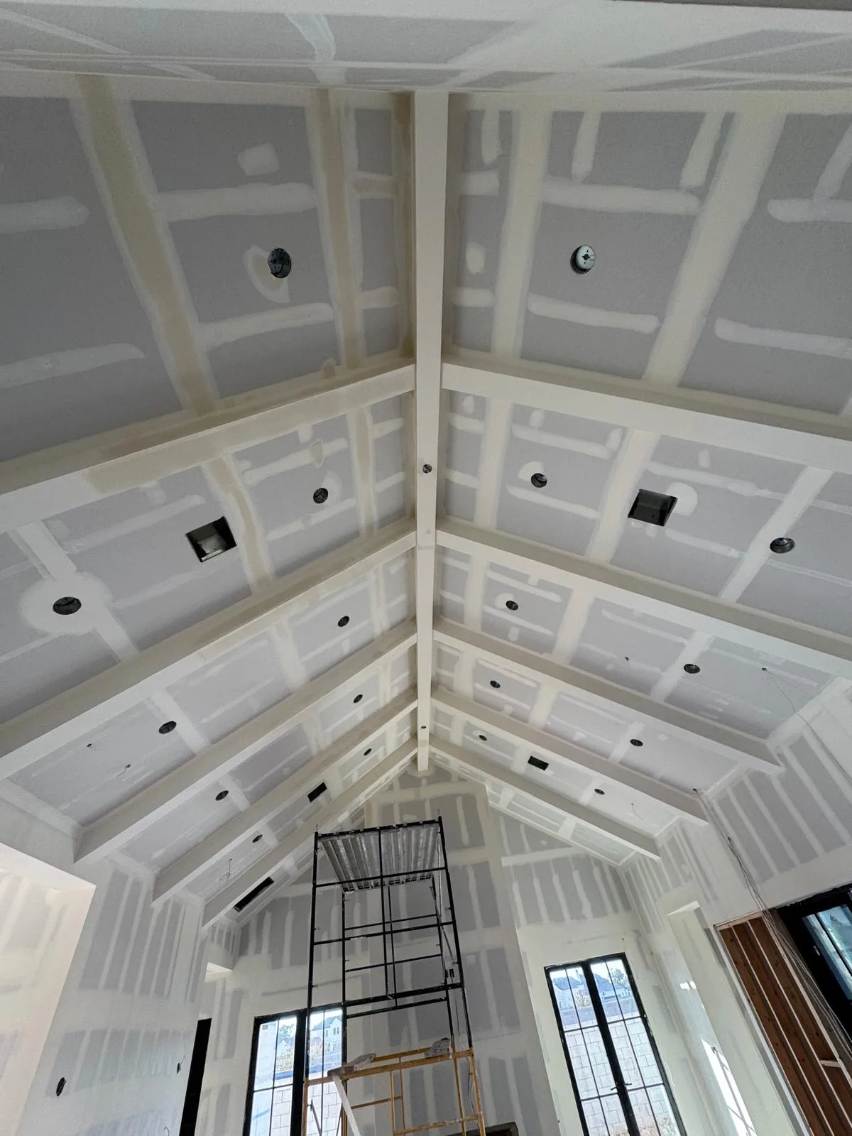 Interior remodel with new drywall installed across walls and a vaulted ceiling